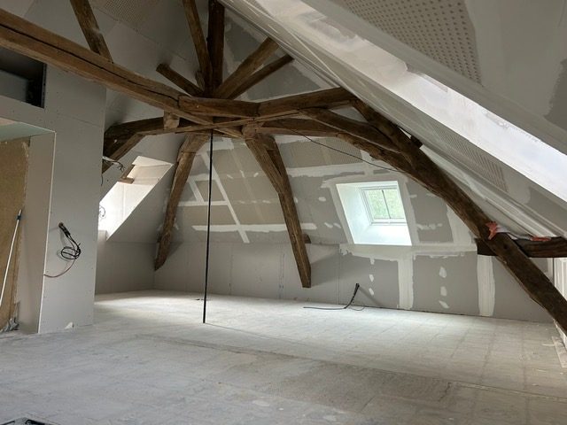 Combles aménagés sous une charpente ancienne en chêne conservée