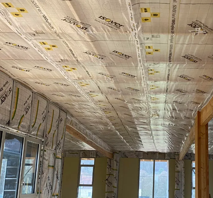 Membrane d’étanchéité à l’air agrafée sous un plafond isolé, en cours de chantier