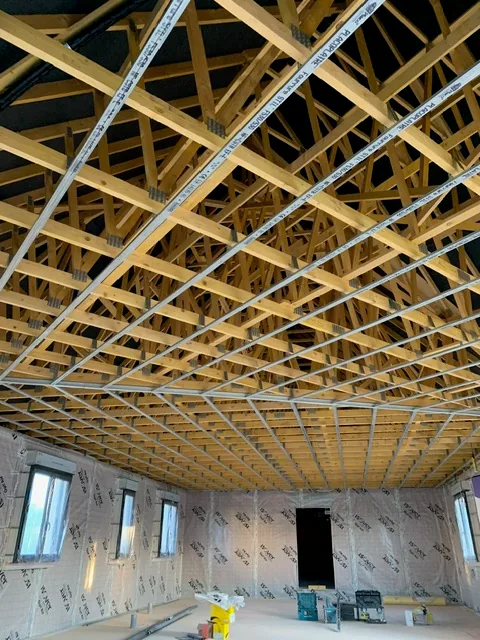 Ossature métallique de plafond sous des fermettes, membrane d’étanchéité à l’air posée