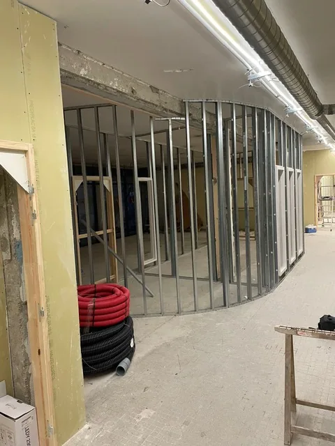 Ossatures métalliques de cloisons courbes en cours de montage dans des bureaux