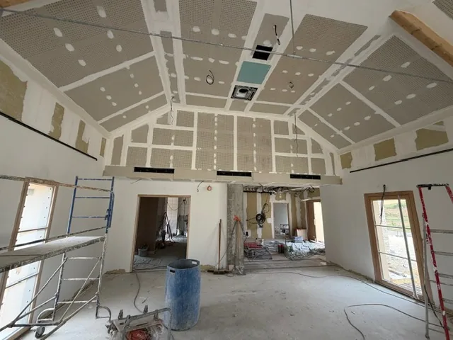 Grande salle en cours de plâtrerie, plafond rampant en plaques jointoyées