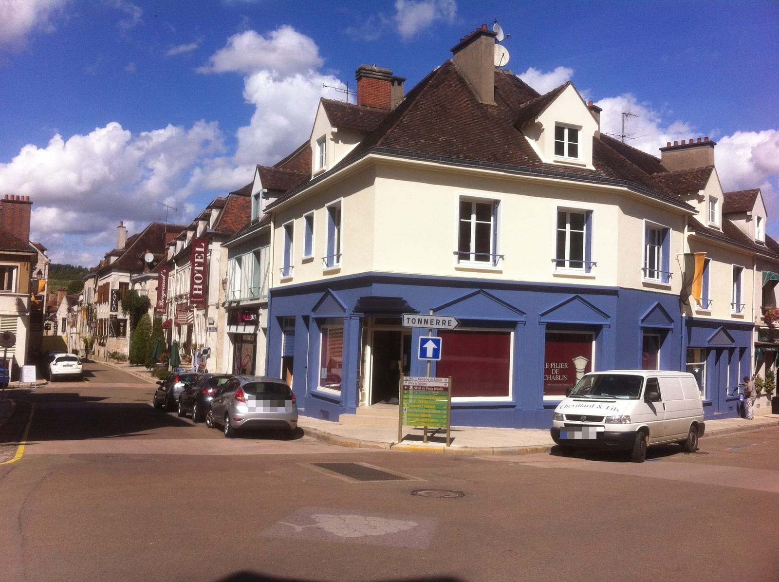 Façade commerciale d’angle ravalée à Chablis : étages crème, devanture bleue