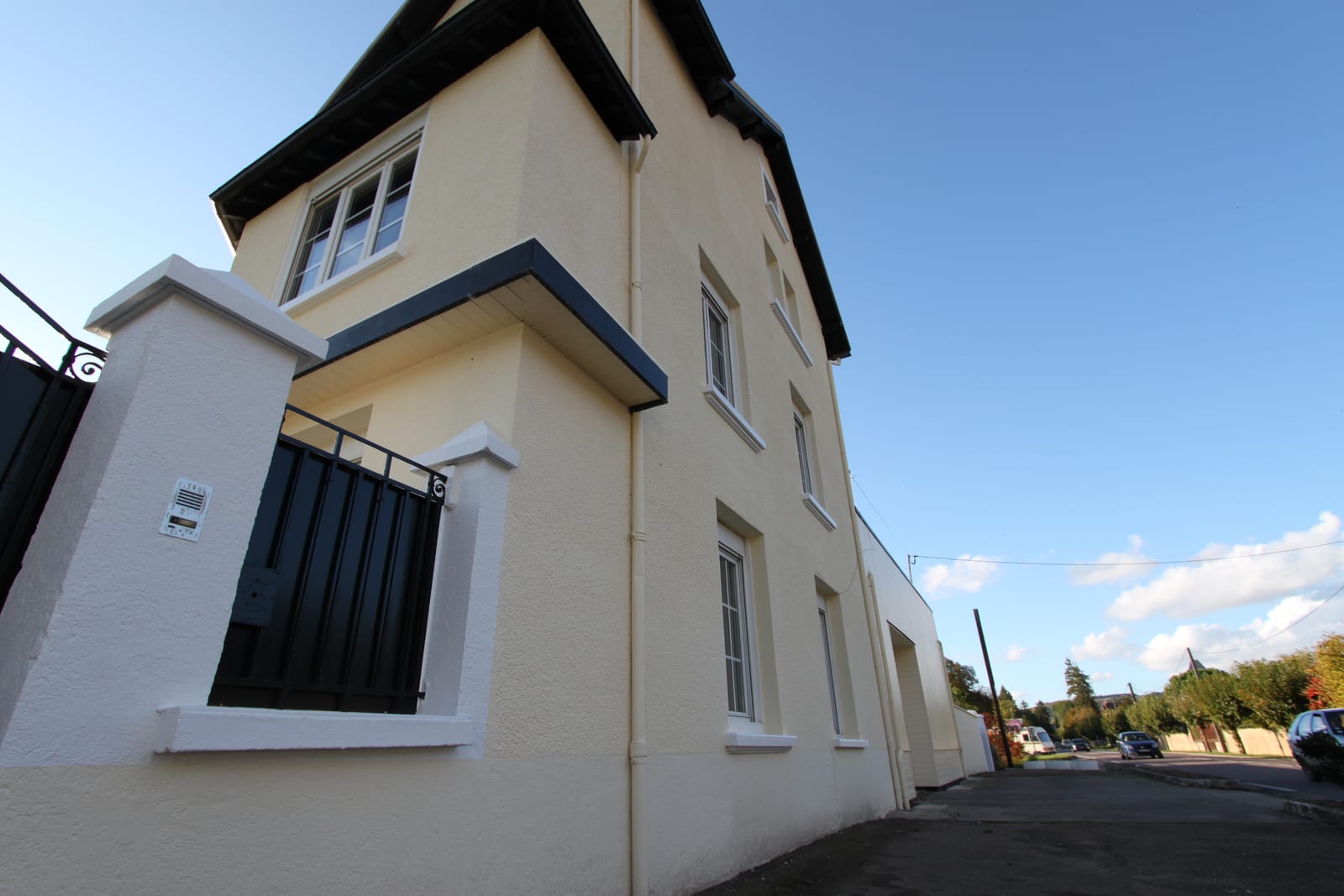 Maison ravalée à Cravant : façade peinte en jaune pâle, encadrements blancs, débords de toit sombres